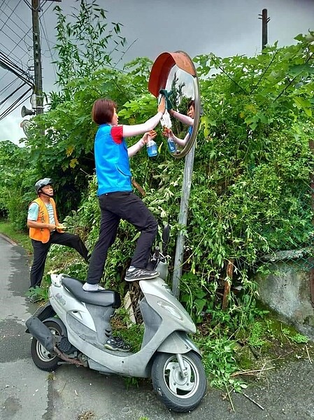 擦亮道路反射鏡，里長帶上全套裝備。夏維鴻攝影