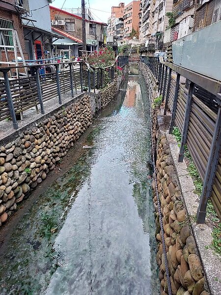 經過整頓的水溝，水清鱼游，溝邊的房舍塗上七彩色澤。圖／記者曾慎昭攝影