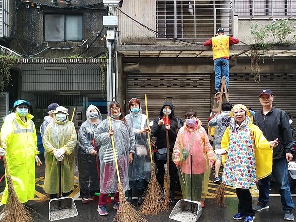 為了里內的環境衛生，下著大雨志工團隊，還是穿著雨衣，打掃防火巷弄！圖／里長提供