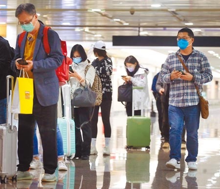 中央流行疫情指揮中心10日公布，國內新增2例境外移入新冠肺炎確定病例，分別自印尼及菲律賓入境，在桃園機場入境管制區內，一群剛下機的旅客正在上網登錄入境健康資料。（范揚光攝）