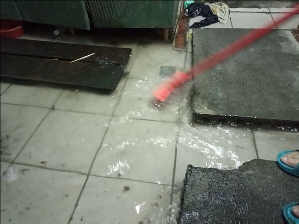 壢景町旁邊一戶鐵皮民宅,現在每逢下雨,水溝水都會回灌到室內,在家走路還要鋪石頭墊高防止滑倒,淹水時甚至連馬桶水都會滿出來。圖/市議員彭俊豪提供