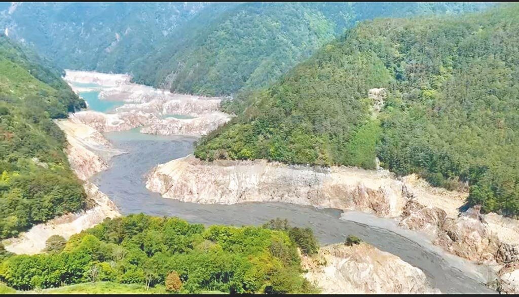 由於持續不下雨,德基水庫上游乾涸僅剩大片黑泥,水庫岩壁嚴重裸露。(民眾提供/陳淑娥台中傳真)