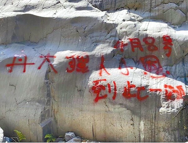 信義鄉丹大溪流,岩石被噴漆「到此一遊」。(楊姓民眾提供/廖志晃南投傳真)