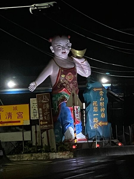 新北萬里往金山方向路邊有金山財神廟的巨大神像,晚間會打白燈,不少路過的民眾都被嚇著。圖/張錦豪提供