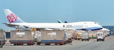 新冠肺炎疫情衝擊華航機師風暴擴大，又增2貨機機師染疫，圖為在桃園機場的貨機坪上，1架華航747-400貨機旁堆滿準備裝載的貨物。（中時資料照片）