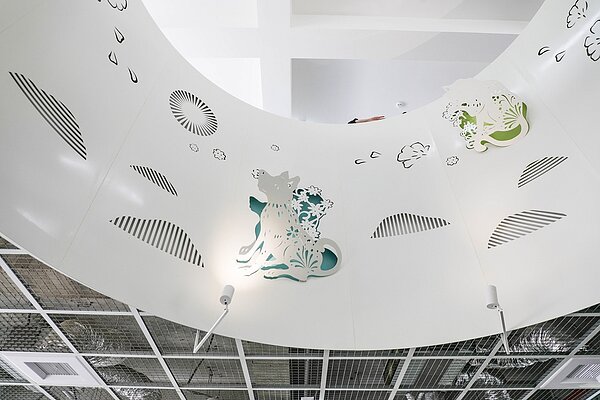 動物之家后里園區,建築外觀與設計別出心裁,以犬隻造型為意象,並大量採用圓弧曲線,陽光充足、空氣流通,園內處處可見剪紙藝術裝置,充滿蓬勃生命力,柔化動物收容所昔日的冰冷形象。。圖/台中市政府提供