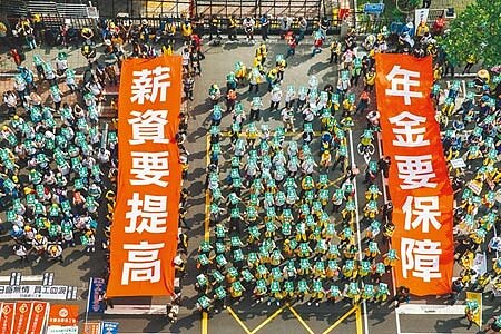 
勞工團體1日舉辦五一勞工大遊行，號召逾3000人參與，民眾遊行至立法院前時拉起「薪資要提高」、「年金要保障」布條，訴求立院「最低工資法」、「勞保年金改善方案」盡速審議通過。（郭吉銓攝）
