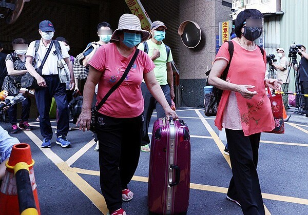 新北板橋某大樓有人確診,新北市府全面清空大樓,所有居民拖著行李,搭乘防疫專車至集中檢疫所。聯合報系資料照