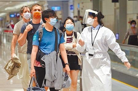 
疫情指揮中心11日公布國內新增5例境外移入新冠肺炎確定病例，分別自南非、越南及日本入境。在桃機入境管制區內，檢疫人員正帶領數名旅客，準備前往集中檢疫所。（范揚光攝）
