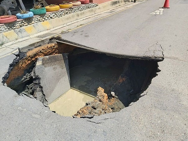 桃市大園區圳頭軍史公園入口處道路，突然崩塌出現「天坑」，民眾擔心危及台61線高架道橋墩安全。圖／卓榮騰提供