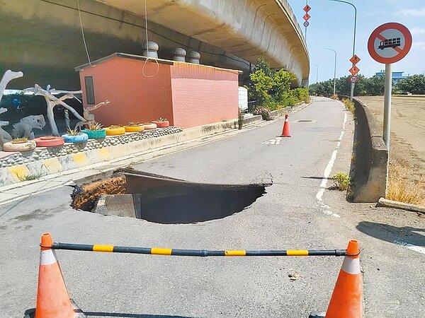 桃園市大園軍史公園旁道路13日早上驚見「天坑」,深度逾8公尺,在地圳頭里長卓榮騰獲悉緊急圍起戒備,避免人車誤入。(卓榮騰提供/蔡依珍桃園傳真)