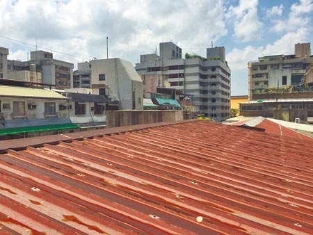 台北市不少老公寓在頂樓加蓋斜屋頂防漏水，但因為限高1.5公尺，進入只能蹲低身體變成「哈比人」相當不便。圖／記者張立勳攝影