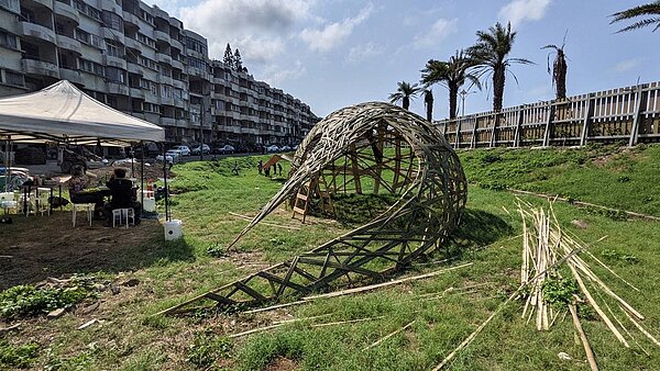 翻轉北海岸海灣新城社區形象,新北市城鄉局協助社區整合與環境提升,在居民、藝術家、志工的共同創作下,原本陰暗雜亂的竹林,變成開闊、明亮的竹編藝術品與綠意盎然草地,要抹除過去海灣新城「北海岸鬼屋」形象。圖/新北市城鄉發展局