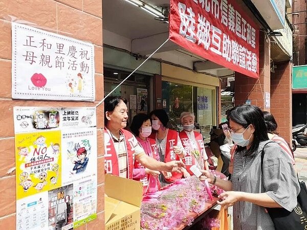 尹俊富在母親節時,發放康乃馨給里民。圖/取自信義區正和里尹俊富臉書