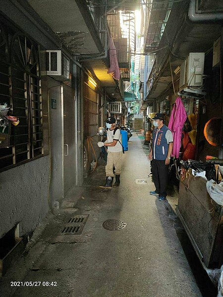 志忠里長隨消毒人員一起清掃里內各戶,將防疫工作徹底執行。圖/謝志忠提供