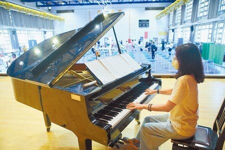泰北中學校方為安撫學生情緒,特地安排老師在現場彈奏樂曲。(張鎧乙攝)