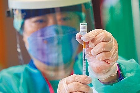 指揮中心表示,預計先提供成人接種BNT兩劑並觀察心肌炎情況,再規畫青少年施打第2劑,並透露BNT兩劑間隔可望縮短為6周。圖為醫護人員用針管抽取BNT疫苗。(張鎧乙攝)