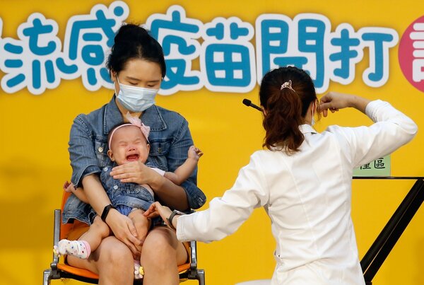 衛福部疾病管制署昨天上午舉行「守護我們所愛的人」公費流感疫苗開打記者會，邀請一對父母帶著雙胞胎幼兒到現場接種，小女嬰打針後當場大哭。記者鄭超文／攝影 