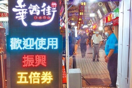 華西街夜市入口處的電子跑馬燈不斷顯示「歡迎使用振興5倍券」，準備迎接商機。（姚志平攝）