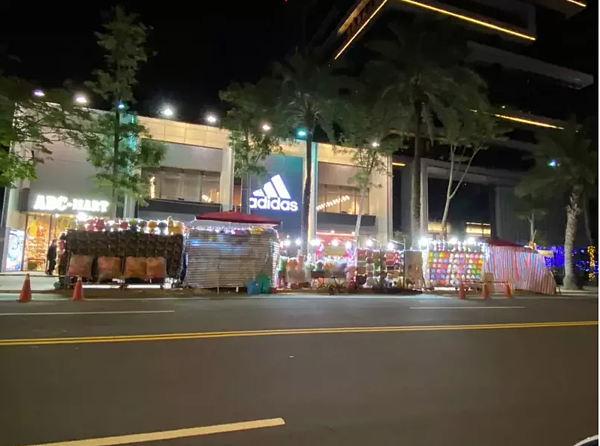 位於士林夜市基河路上的「圓山1號院」豪宅前,白天是豪宅,但每到晚上門口淪為夜市,住戶抱怨無照攤販擋住社區車道視線,造成危險。圖/議員汪志冰提供