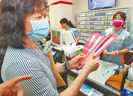 完成「第一梯次紙本券」振興五倍券登記的民眾,8日開始至超商領用,民眾依規定向店員領取五倍券。(鄭任南攝)