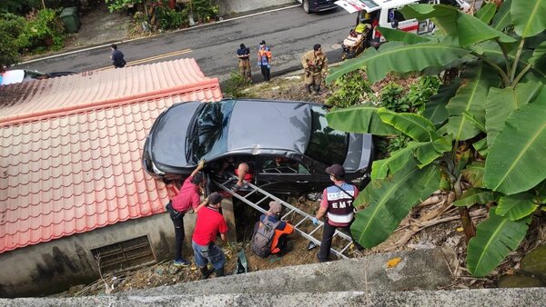 台南楠西灣丘里一輛轎車出現在路邊民宅屋頂。圖／台南市消防局提供