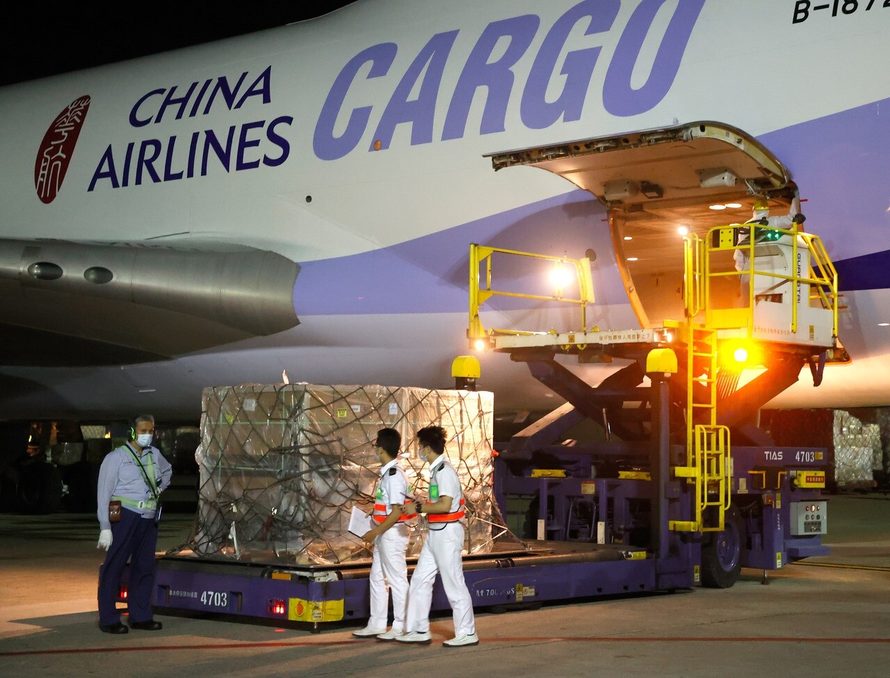 政府採購的第8批莫德納疫苗日前運抵桃園機場，海關人員在機邊執行驗放通關的程序。記者鄭超文／攝影  