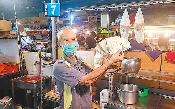 高雄凱旋青年夜市攤商受惠商圈夜市券,開心出示營業收取到的商圈夜市券。(高市經發局提供/柯宗緯高雄傳真)