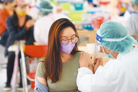 指揮中心調度加開台北市5處大型疫苗接種站，昨天氣溼冷，許多民眾還是把握假日時間前往施打。（鄧博仁攝）