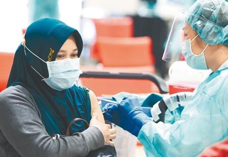 花博疫苗接種站,3日為預約接種AZ疫苗民眾施打,外籍移工也前來接種疫苗。(陳俊吉攝)