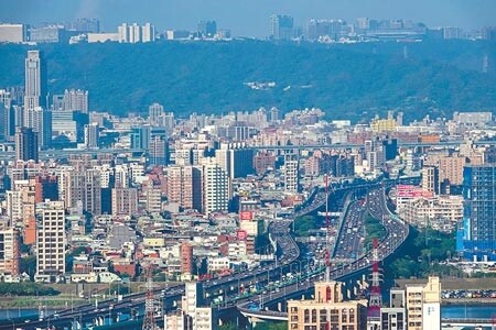 房價居高不下,年輕人想買屋,只能望屋興嘆。圖為五股、圓山段高速公路鳥瞰遠處樓房。(本報資料照片)