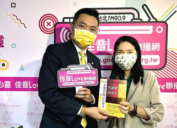 永慶房房屋業管部陳賜傑協理贈送《都會空間》節目主持人黃葳威教授永慶房產集團甫出版的新書《先誠實再成交》。圖／永慶房產集團提供