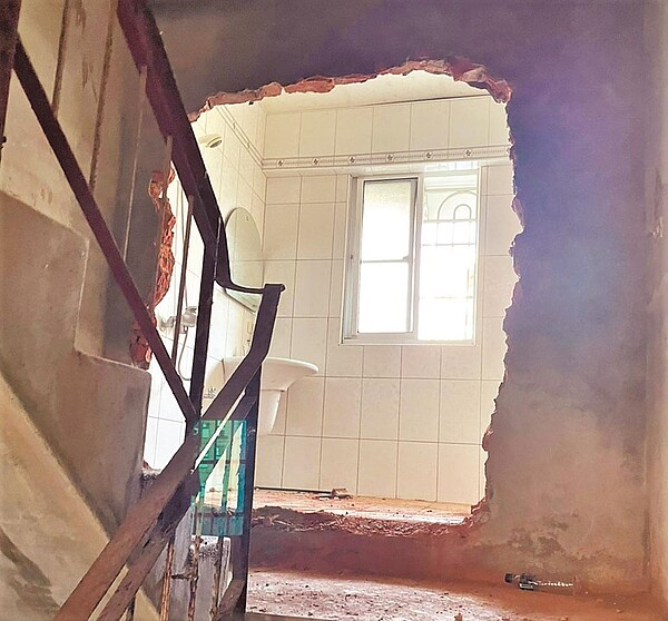 忠山大樓逃生梯外推,住戶用來增加私人空間,設置浴室,堆放瓦斯桶、洗衣機甚至是大批雜物。(高市工務局提供/袁庭堯高雄傳真)