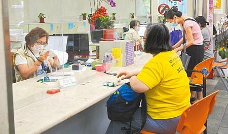 若勞工年滿60歲,工作年資未滿15年僅可選擇請領一次金,但若滿15年以上者,得選擇請領月退休金或一次退休金。圖為勞保局台北市辦事處的櫃檯人員服務民眾的情形。(張鎧乙攝)