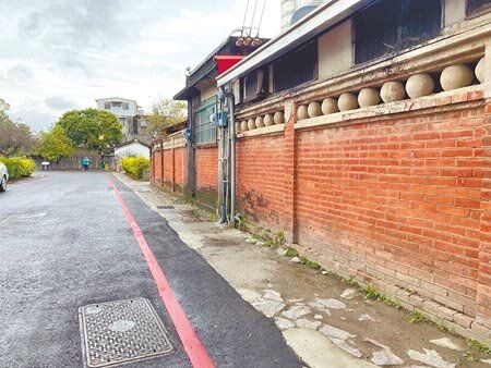 新竹縣北埔老街去年施作電纜地下化工程,原先石板鋪面如今以柏油取代,並在古蹟周邊畫上紅線,遭居民批評「沒有美感」、隔出與古蹟的距離。(莊旻靜攝)