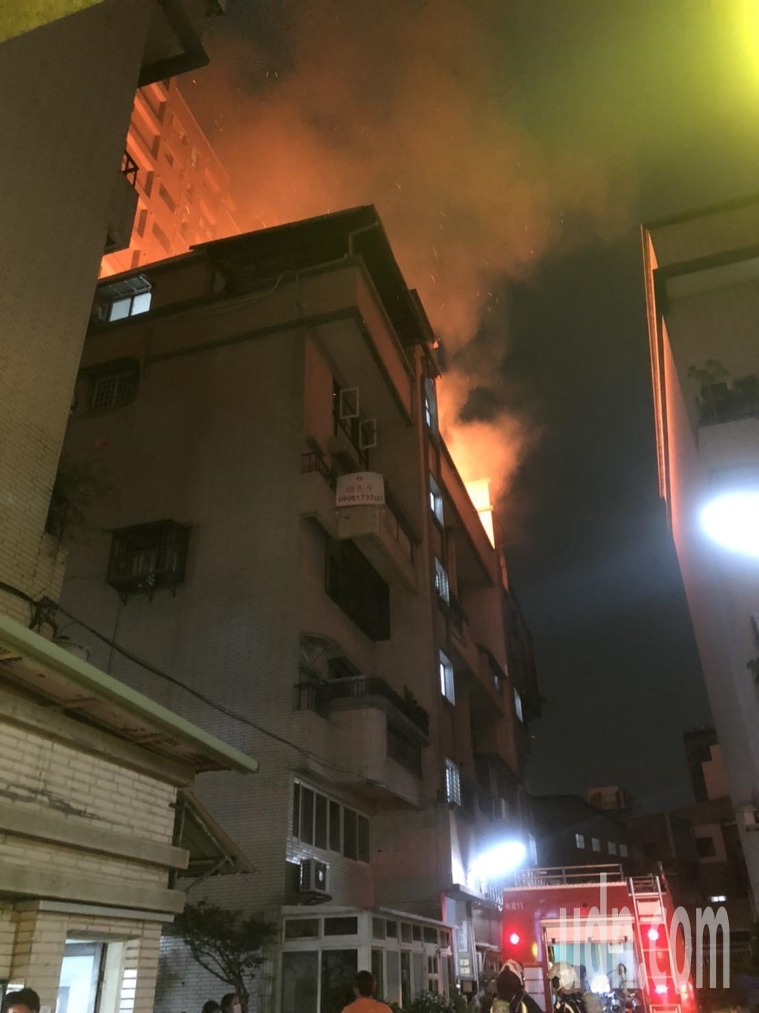桃園區一處社區大樓樓頂起火，消防人員正在撲滅中。記者曾健祐／攝影 