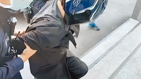 疫情指揮中心昨提醒,民眾規勸對方戴口罩時仍要注意自身安全。圖為凶嫌蔣姓男子21日送往龜山派出所時,上樓梯數度腿軟跪地,還要兩旁員警一路邊扛邊扶才能進入警所。(蔡依珍攝)