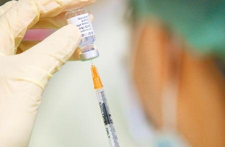 中央流行疫情指揮中心雖已暫緩12~17歲青少年接種第二劑BNT疫苗,全台已有1036人接種,引起議論。圖為醫護人員在台北花博接種站抽取BNT疫苗。(張鎧乙攝)