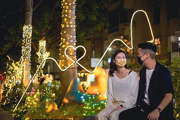 跨年主題燈飾營造魔幻森林的浪漫氛圍,吸引情侶拍照駐足。圖/台北市政府觀光傳播局提供