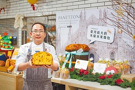 
吳寶春手持帶領團隊參賽的米蘭式潘尼朵妮麵包（比賽版）；身後是北中南3家吳寶春麥方店旗艦店展示的6公斤版，堪稱是全台最大。（吳松翰攝）
