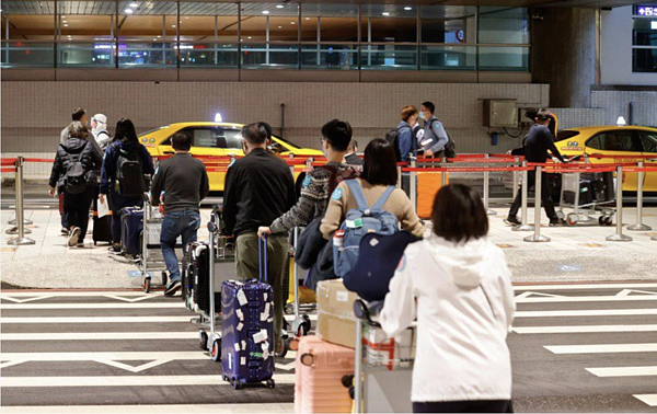 隨著春節將屆，防疫旅館量能緊張。圖為為桃園機場旅客排隊等候搭乘防疫計程車。 圖／聯合報系資料照片