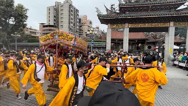 2021年11月24日，艋舺青山王行經位階較高之觀世音菩薩所在的艋舺龍山寺時，為表尊重，神轎須熄燈並快步衝過廟門，謂之「衝轎」。（張哲生拍攝）