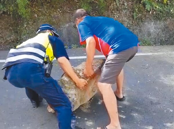 花蓮縣14日地震不斷，竟有近百公斤的大石落在193縣道上，靠警民協力將其移至路邊。（警方提供／羅亦晽花蓮傳真）