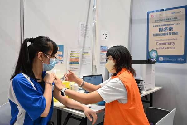 香港掀起是否需要接種第三劑疫苗的討論風潮。圖為一名中學學生接種新冠疫苗。圖／中通社

