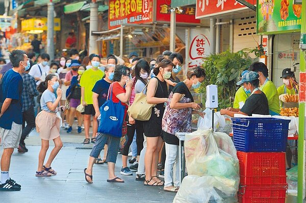 微解封後第一個周末,新北八里渡船頭老街的雙胞胎名店湧現排隊人潮。圖/張鎧乙攝