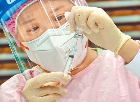 打疫苗並非萬靈丹!疫情指揮中心昨公布新增3例境外移入個案,其中2例都是分別接種2劑BNT和AZ疫苗後仍然確診。圖為醫護人員全神貫注抽取疫苗,不浪費一絲一毫。(本報資料照片)