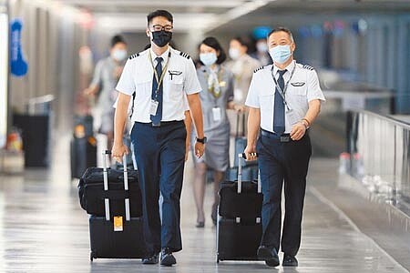 Delta變異病毒來勢洶洶,自7月21起將加強國籍航空機組員返台檢疫措施。圖為桃園機場內機組員準備入境。(陳麒全攝)