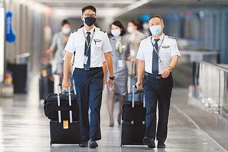 
Delta變異病毒來勢洶洶，自7月21起將加強國籍航空機組員返台檢疫措施。圖為桃園機場內機組員準備入境。（陳麒全攝）
