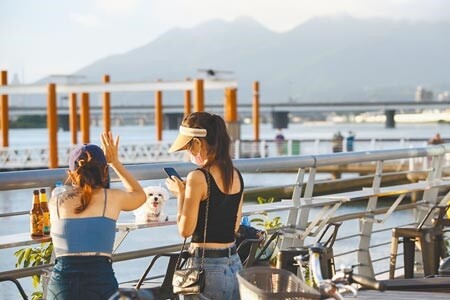 輕颱烟花行進緩慢、路徑直逼台灣東北角，微解封後20日傍晚許多民眾前往大稻埕欣賞夕陽。（鄧博仁攝）