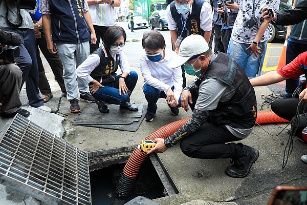 中颱烟花來襲,台中市長盧秀燕(中)22日視察道路側溝清淤作業,以科技偵測發現大量「油塊」卡在溝邊。記者喻文玟/攝影